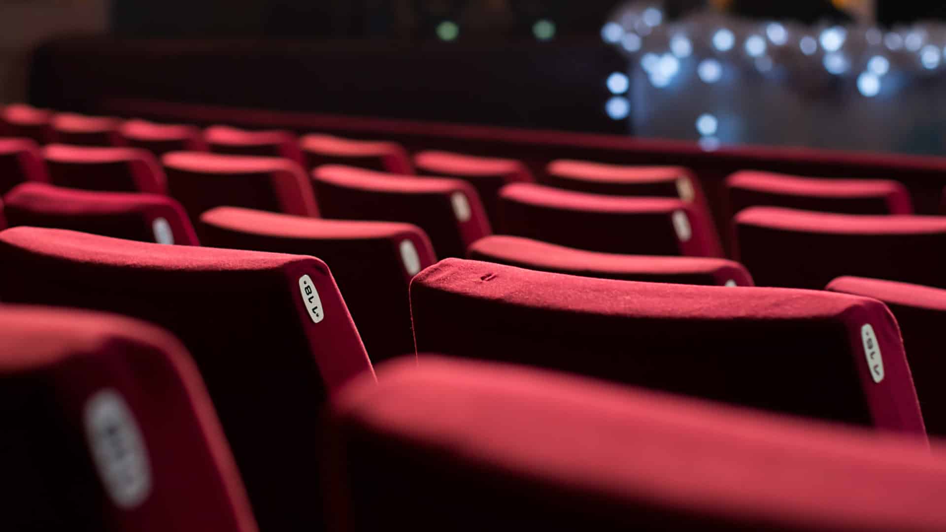 Empty theater with red chairs. Rear view.